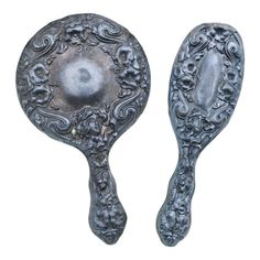 two spoons with ornate designs on them are shown against a white background, one has an oval shaped handle and the other is curved