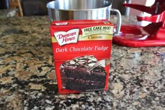 a package of chocolate fudge sitting on top of a counter next to a cup