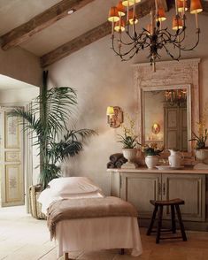 an image of a bedroom with chandelier and mirror on the wall above it