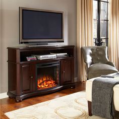 a living room with a couch, chair and television on the stand in front of it