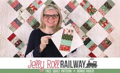 a woman holding up a piece of quilt in front of a wall with the words jelly roll railway on it