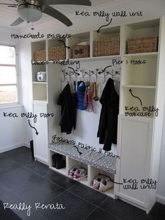 an organized mudroom with clothes hanging on the wall