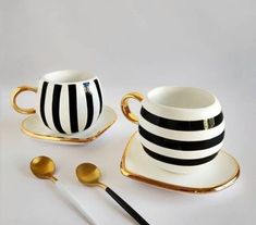 black and white striped tea set with gold trimmings on the saucer, cup and spoon