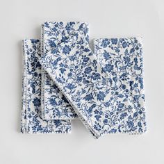 two blue and white napkins on top of each other, one with a flower pattern