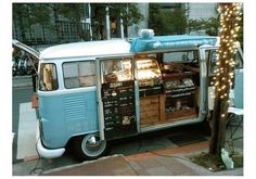 an old blue and white van parked on the side of the road next to a tree