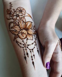 a woman's arm with hendix and flowers on it