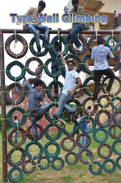 several people climbing on an obstacle made out of tires and rubber rings, with the caption'tyre wall climbing'above them