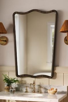 a bathroom with a sink, mirror and two lights on the wall above it is shown