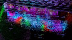 raindrops are reflected in the wet ground next to a computer keyboard and mouse