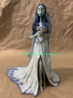 the corpse bride figurine is posed on a brown background with her hands in her pockets