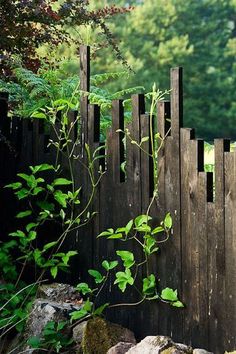 a wooden fence surrounded by rocks and plants