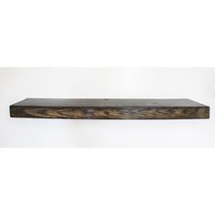 a wooden shelf sitting on top of a white wall