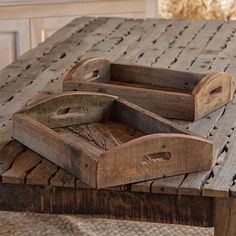 two wooden trays sitting on top of a table