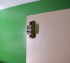 a door handle on the side of a green and white wall