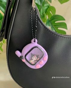 a purse with a key chain hanging from it's front pocket and an owl in the window