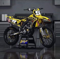 a yellow dirt bike sitting on top of a table