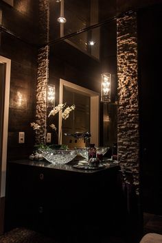 a bathroom sink sitting under a large mirror next to a wall mounted faucet