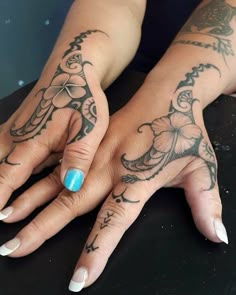 two hands with tattoos on them, one has a blue ring and the other has an elephant