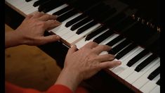 two hands are playing the piano with their fingers