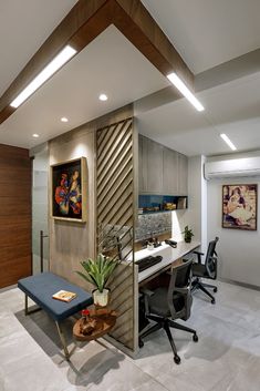 an office with a desk, chair and painting on the wall in it's corner