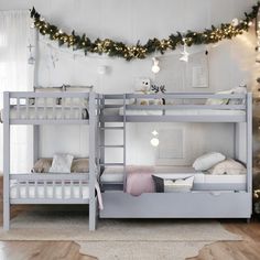 there are two bunk beds in the room with christmas lights on the wall above them