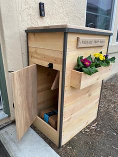 a wooden planter with flowers in it on the side of a building