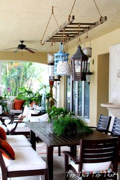 an outdoor living room with lots of furniture and plants on the table in front of it