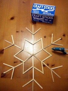 a craft stick snowflake sitting on top of a wooden table