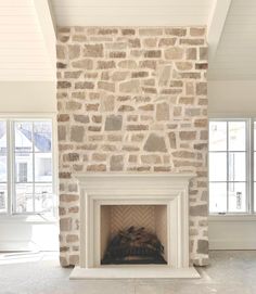 a stone fireplace in the middle of a living room