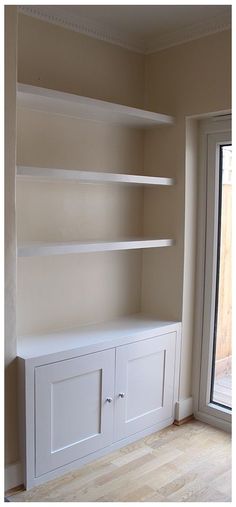 an empty room with white shelves and sliding glass doors