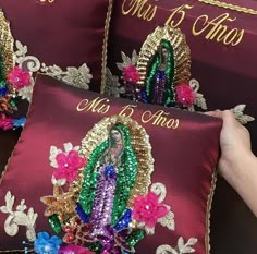 three pillows with the image of jesus on them are being held by someone's hand