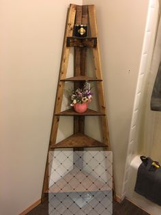 a tall wooden shelf with flowers on top