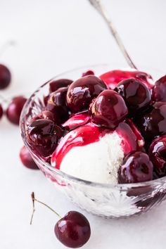 a glass bowl filled with ice cream and cherries