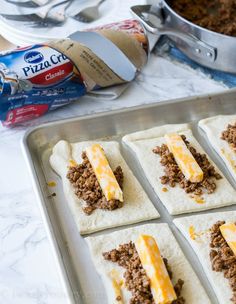 several pita breads with cheese and ground beef on them, ready to go into the oven