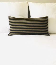 a black and white striped pillow sitting on top of a bed