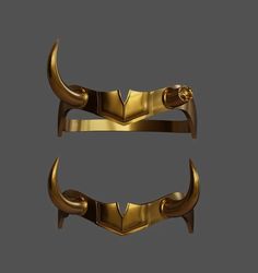 two gold metal handles with horns on each side and a skull in the middle, against a gray background