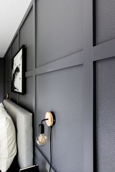 a bedroom with gray walls and white bedding