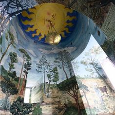 an artistic mural on the ceiling of a building with trees and animals painted on it