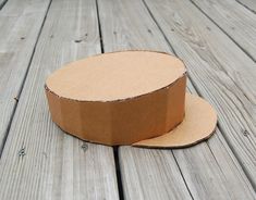 an empty cardboard box sitting on top of a wooden floor next to a piece of cardboard