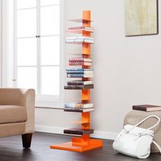 a living room with a chair, book shelf and purse on the floor in front of a window