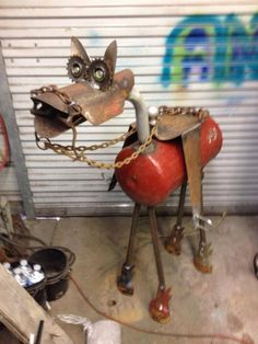 a statue of a dog with chains on it's neck and collar, sitting in front of a garage door