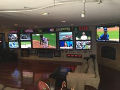 a room filled with lots of tvs and baseball game screens on the wall above them