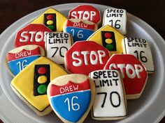 decorated cookies in the shape of stop signs are on a plate with markers and traffic lights