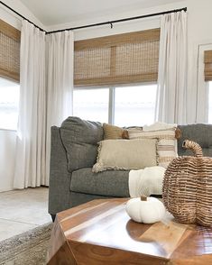 a living room filled with furniture and pillows on top of a wooden table in front of a window