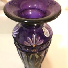 a purple glass vase sitting on top of a table