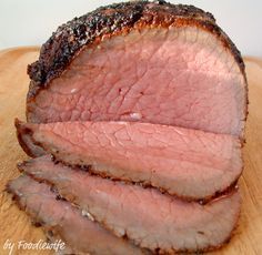 a sliced meat sitting on top of a wooden cutting board