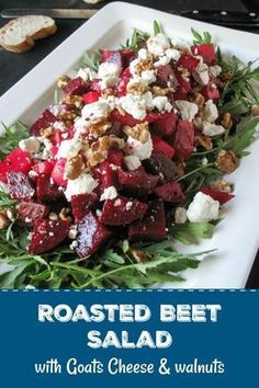 roasted beet salad with goat cheese and walnuts on a white plate next to toasted bread