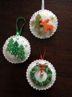 three christmas ornaments are hanging on a table