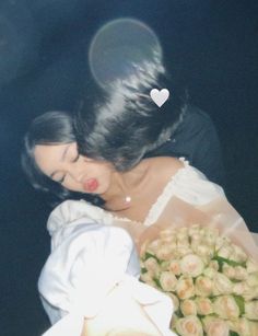 a woman holding a bouquet of flowers in her hand and looking down at the ground