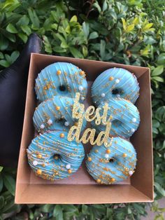 blue donuts with gold sprinkles in a box that says best dad